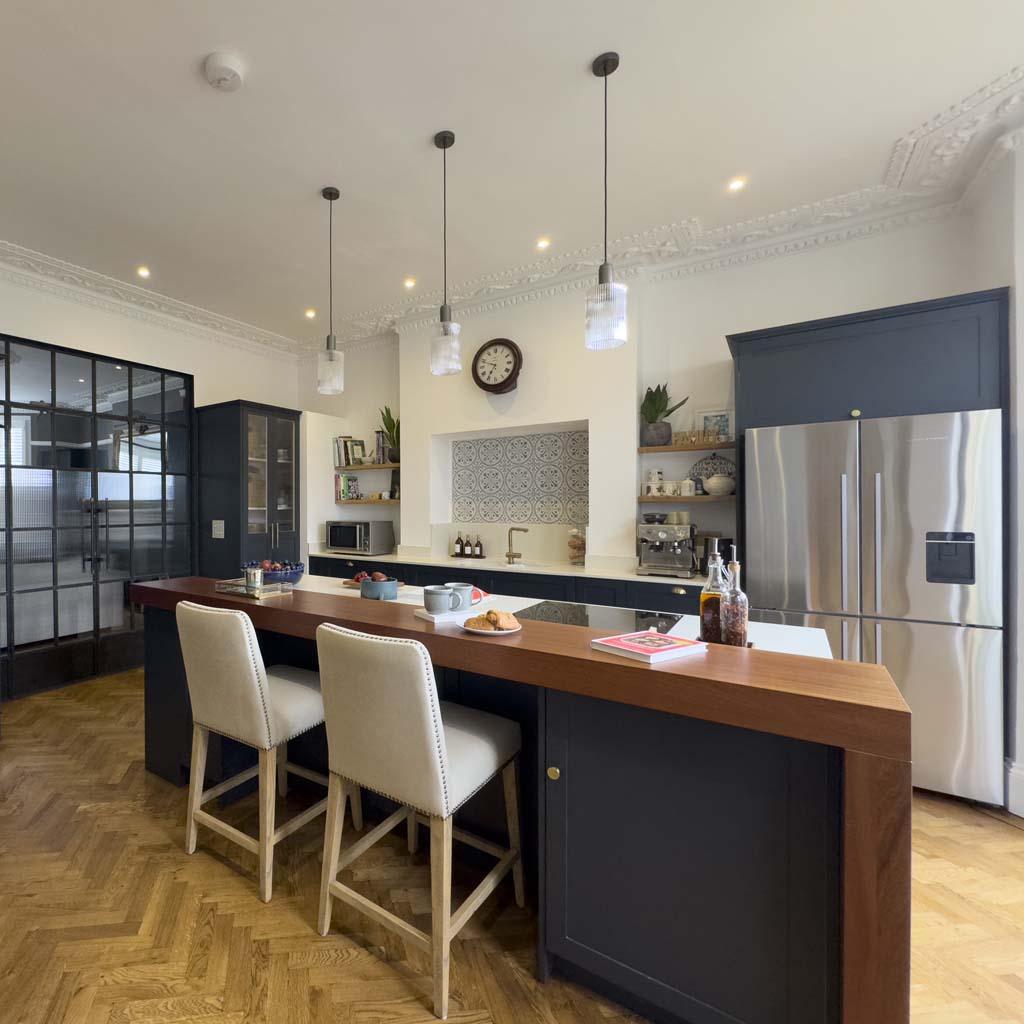 Henleaze period kitchen with navy cabinetry, patterned tile splashback, and wooden island, interior scheme designed by Ivywell Interiors.
