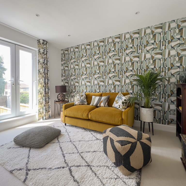 Reception room with mustard yellow velvet sofa, patterned wallpaper, and vintage furniture in a Bedminster townhouse by Ivywell Interiors