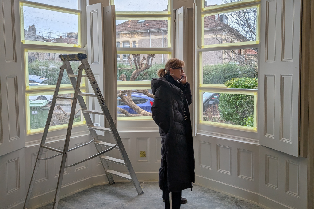 Interior designer on-site coordinating trades during a Victorian home renovation in Bristol.