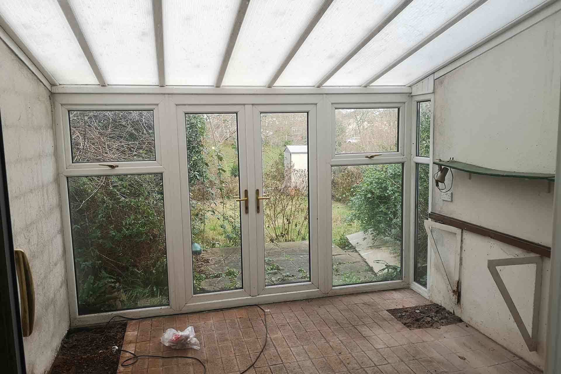1950s kitchen before renovation with outdated layout and poorly insulated conservatory, typical of inefficient mid-century extensions.